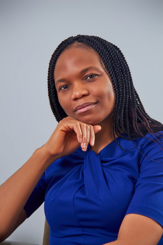 An image of Dr. Eneanwan Ekpo Johnson looking at the camera with her hand under her chin and wearing a blue shirt. 