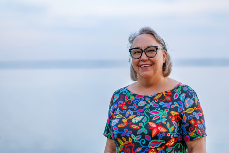 Siila Watt-Cloutier looks at the camera, smiling. She is colourful shirt.