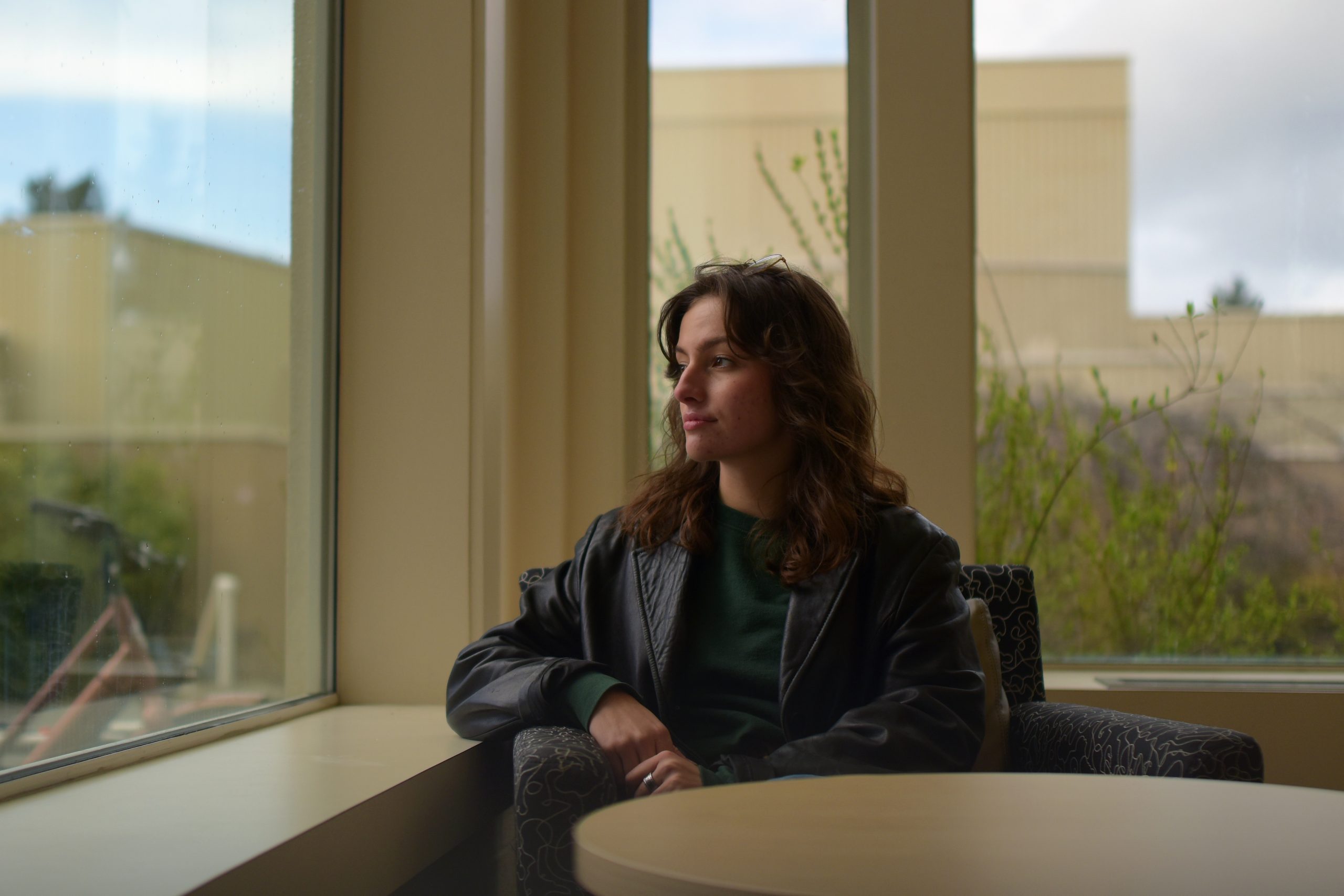 Kennedy Halwa looks out a window while seated at a table.