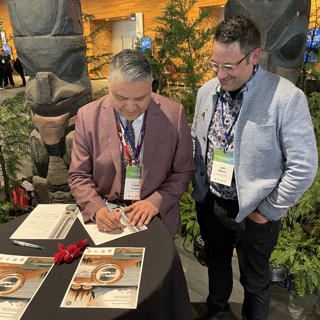 B.C. Assembly of First Nations Regional Chief Terry Teegee signs the Relationship Protocol as PICS Executive Director Dr. Ian Mauro looks on.