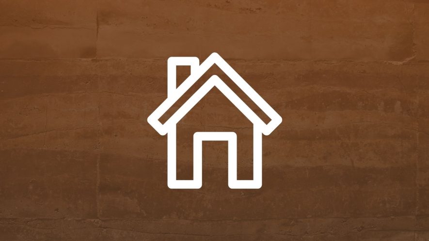 Rammed earth wall with brown gradient and icon of a house overlaid. Photo credit: Neosiam